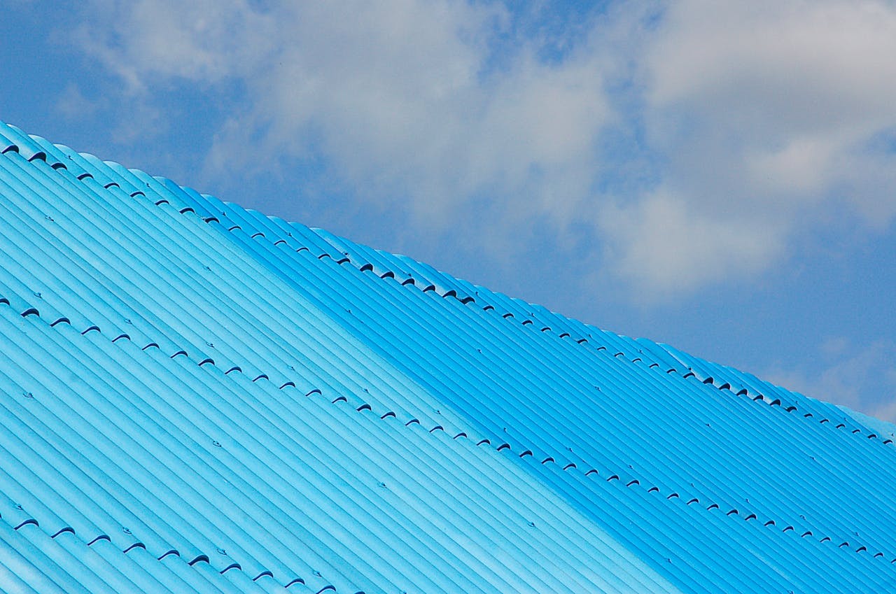 gallery-01 A bright blue corrugated roof shot from a low angle against a clear sky.