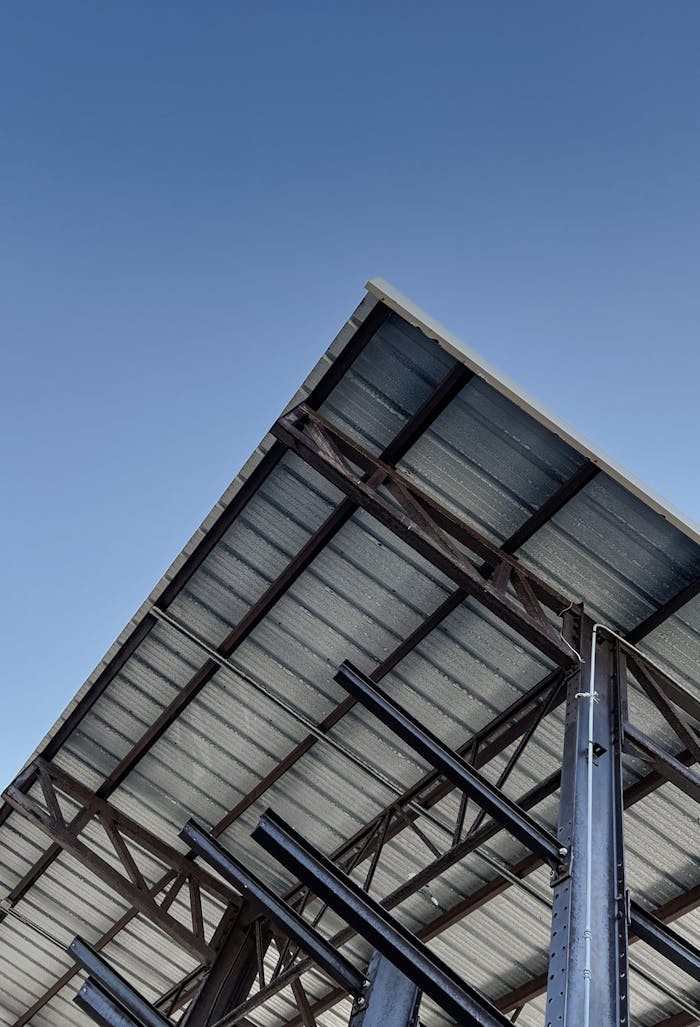 portfolio-03 Angled view of an under-construction steel frame building with a clear blue sky backdrop.