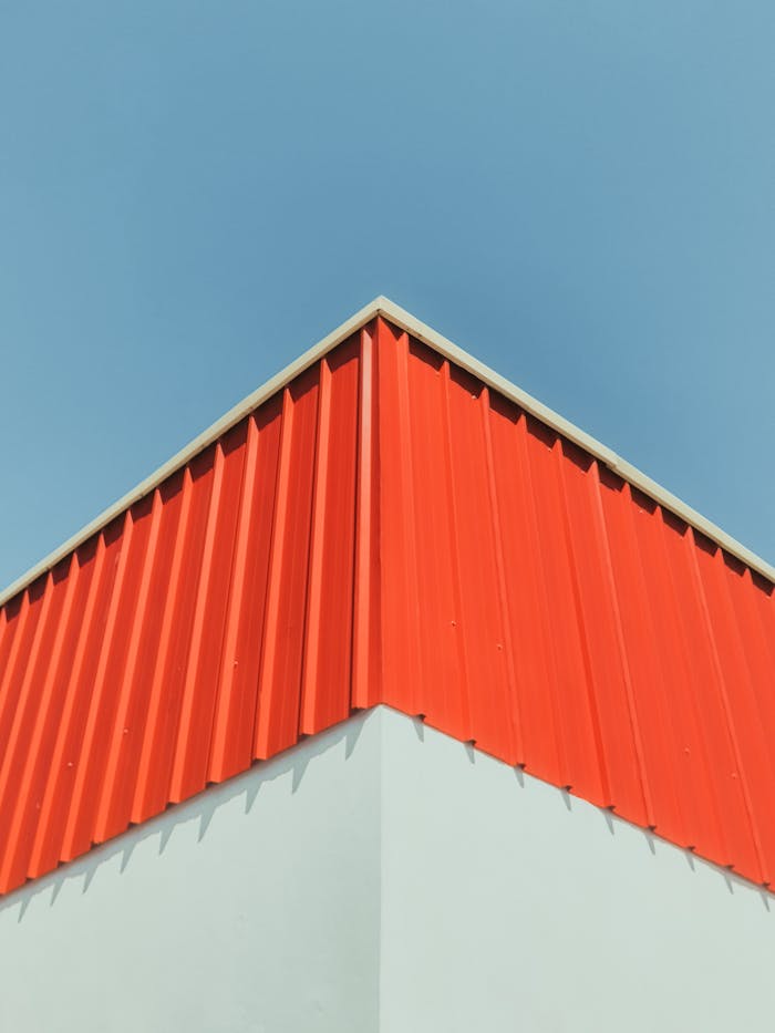 portfolio-02 Minimalist architecture shot of a red metal roof and blue sky, highlighting sharp angles.