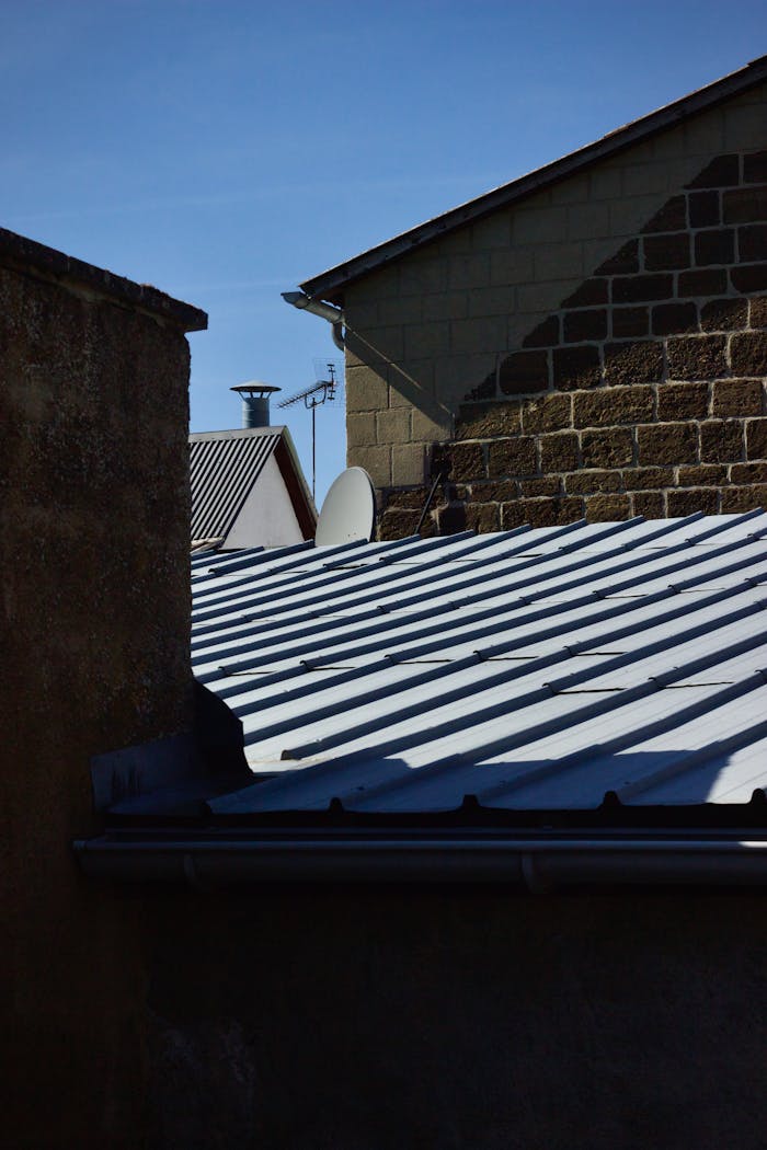 portfolio-01 Abstract view of urban rooftops with dramatic shadow patterns under clear sky.