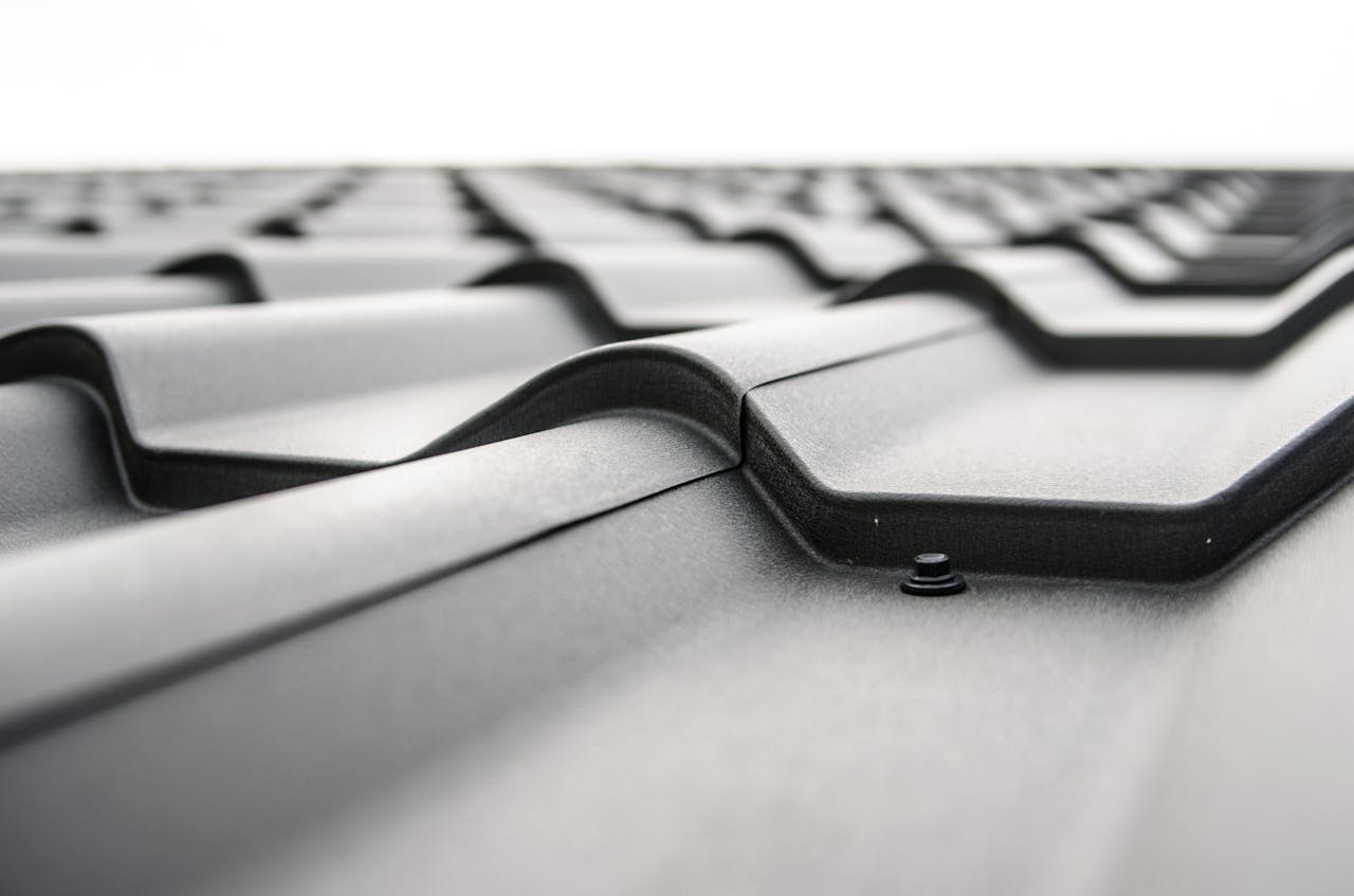 portfolio-01 Close-up view of a metal roof's wavy design showcasing rivets and structural detail.